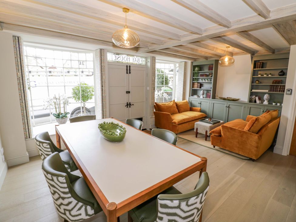 A dining room with a table and seating area at Bay House Cottage in Broadway