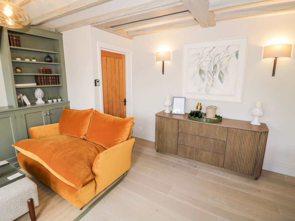 A living room with a sofa and bookshelf at Bay House Cottage in Broadway