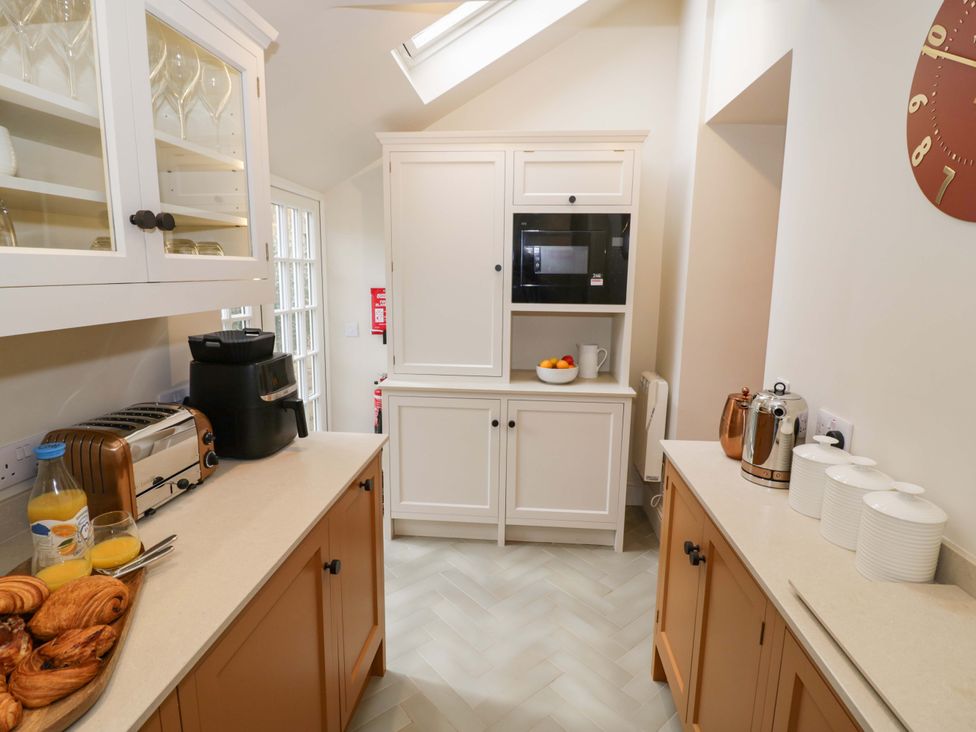 A kitchen with a microwave, toaster, and preparation area at Bay House Cottage in Broadway