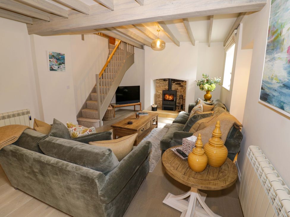 A living room with a sofa and fireplace at Bay House Cottage in Broadway