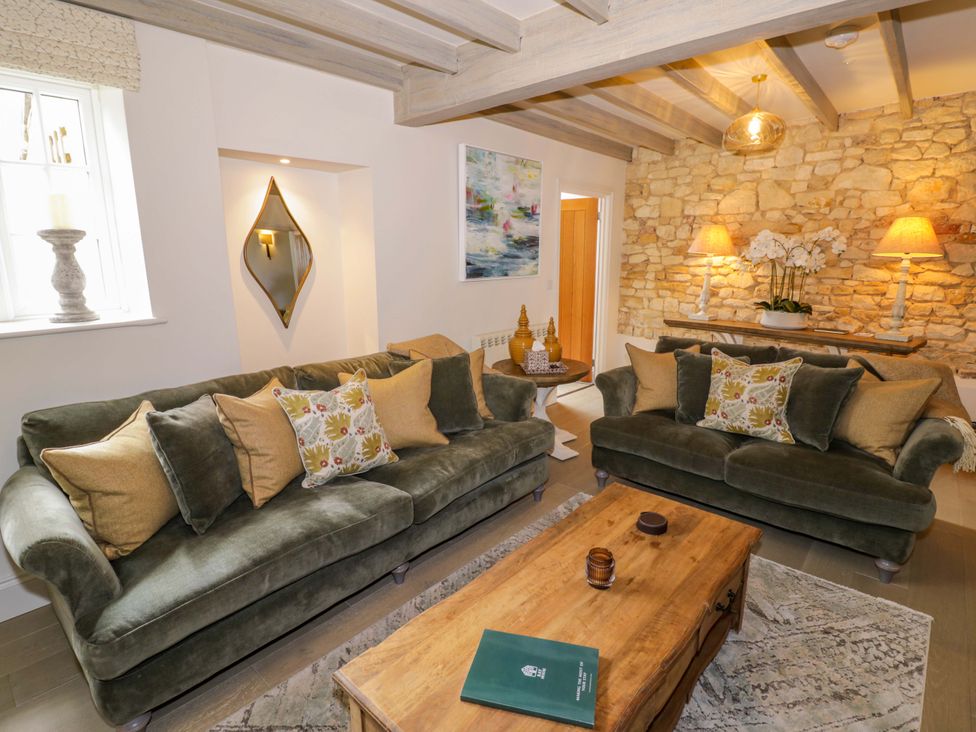 A living room with sofas and a coffee table at Bay House Cottage in Broadway