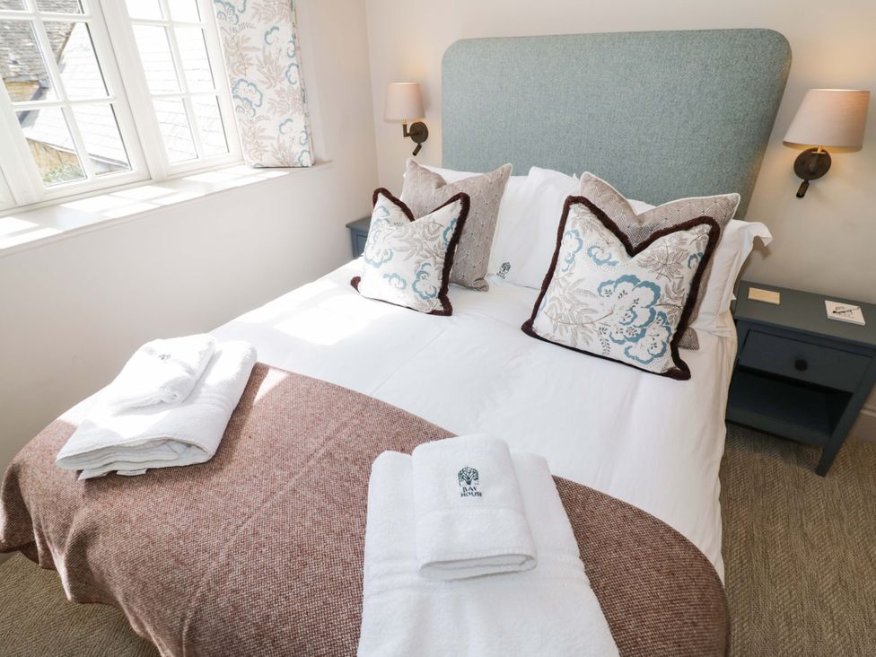 A bedroom with a bed and pillows at Bay House Cottage in Broadway