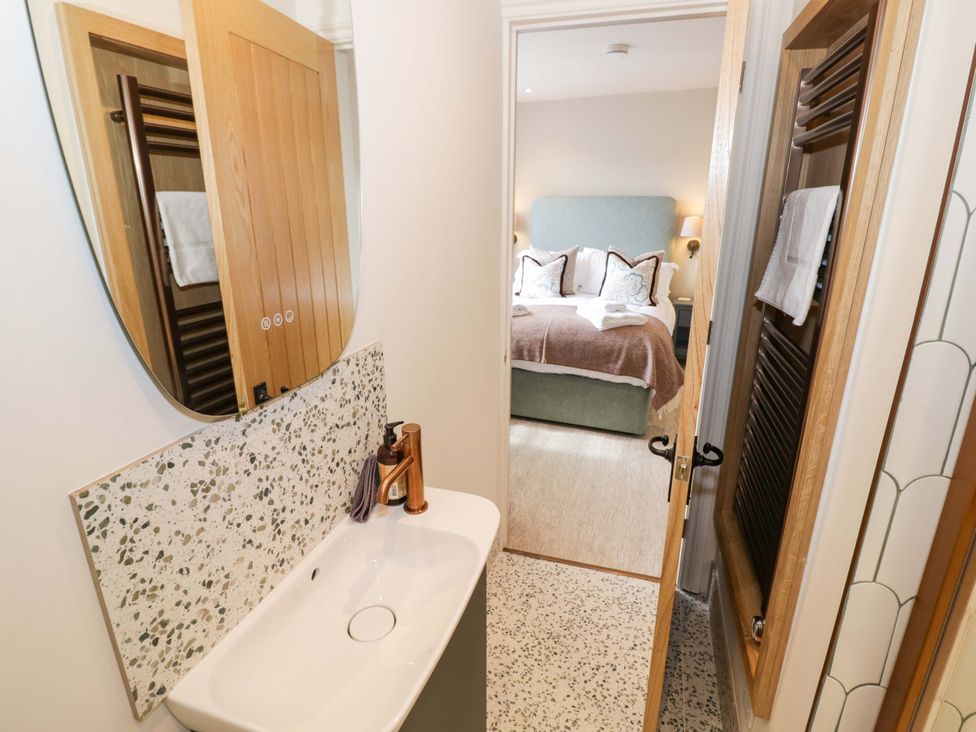 A bathroom with a sink and mirror at Bay House Cottage in Broadway