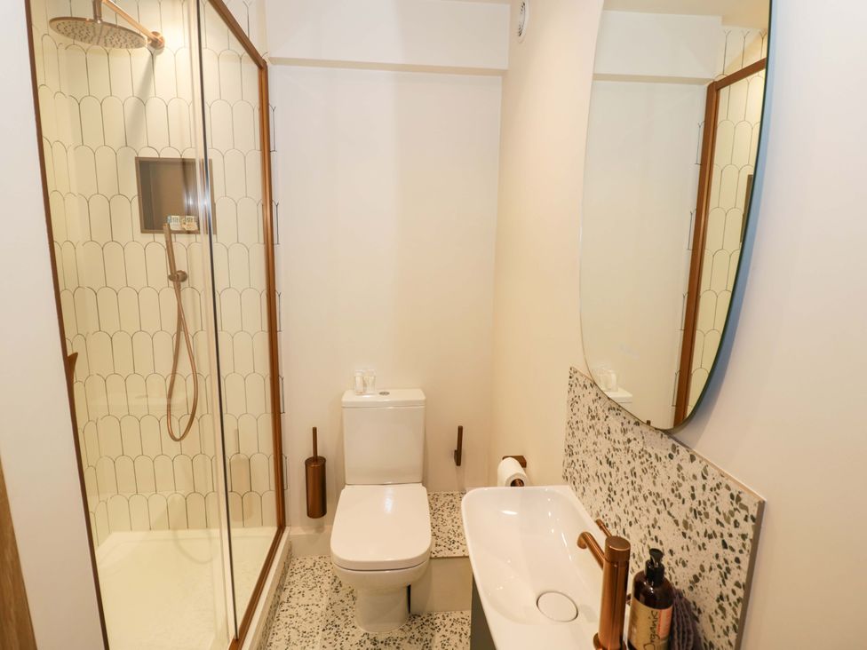 A bathroom with a shower, toilet, and sink at Bay House Cottage in Broadway