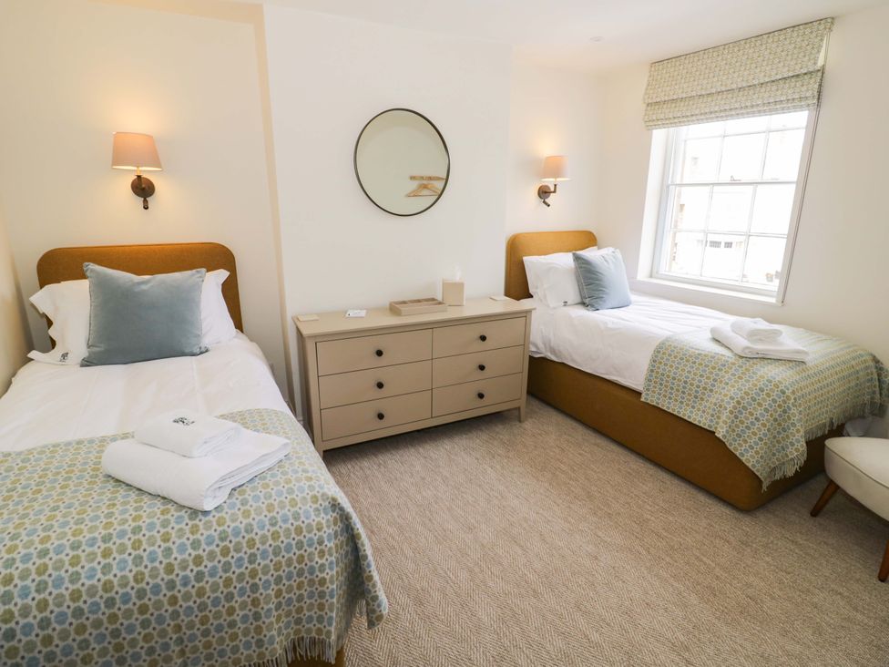 A bedroom with two beds and a dresser at Bay House Cottage in Broadway