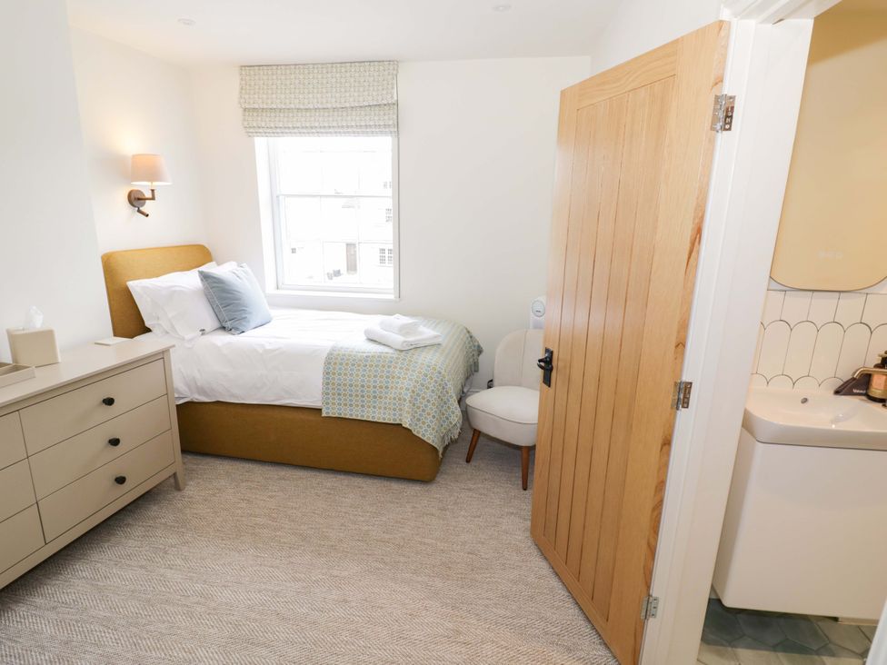 A bedroom with a bed and dresser at Bay House Cottage in Broadway