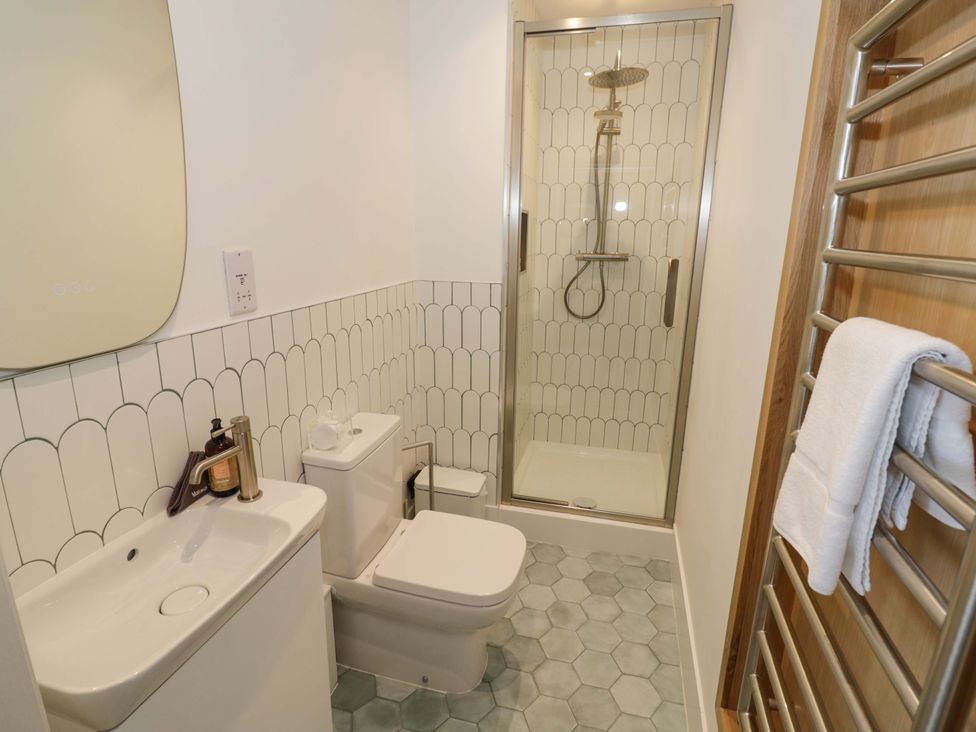 A bathroom with a shower and sink at Bay House Cottage in Broadway