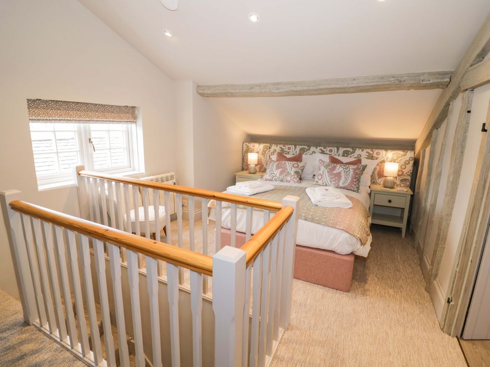 A bedroom with a bed and bedside tables at Bay House Cottage in Broadway