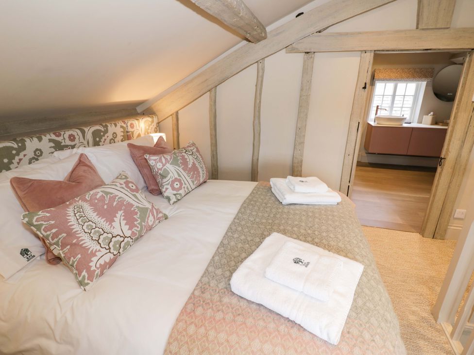 A bedroom with a bed and pillows at Bay House Cottage in Broadway