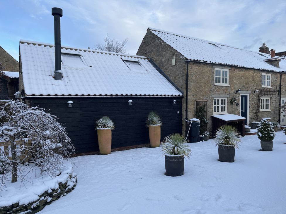 A house and garage covered in snow at A Stones Throw in Sawdon near East Ayton