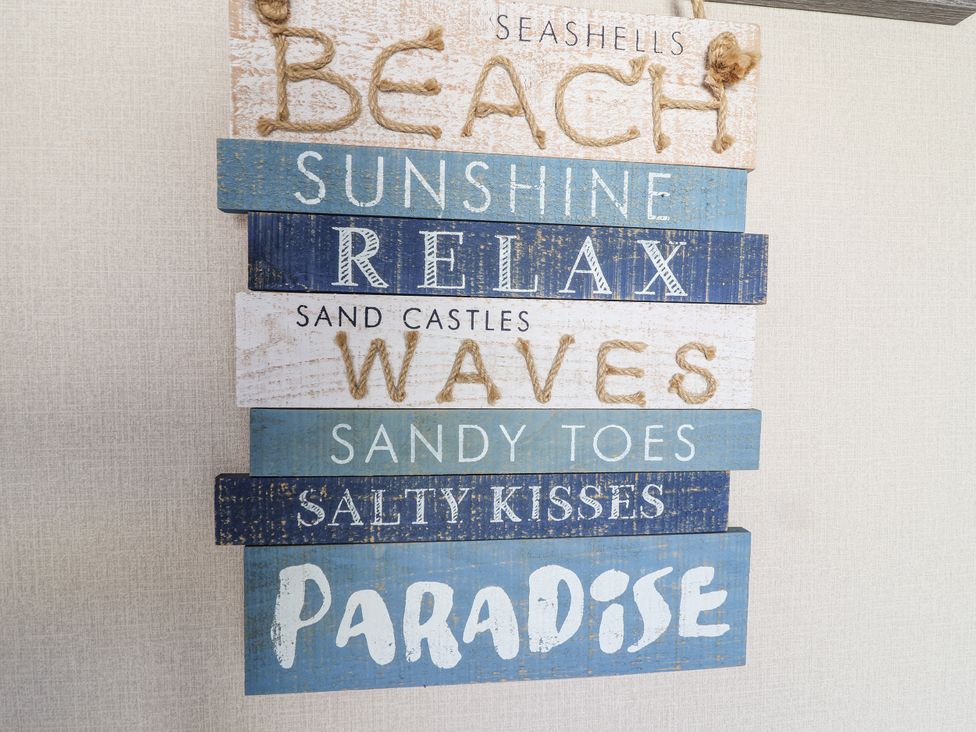 A decorative sign with beach-themed words at Caravan 7 in Plymouth