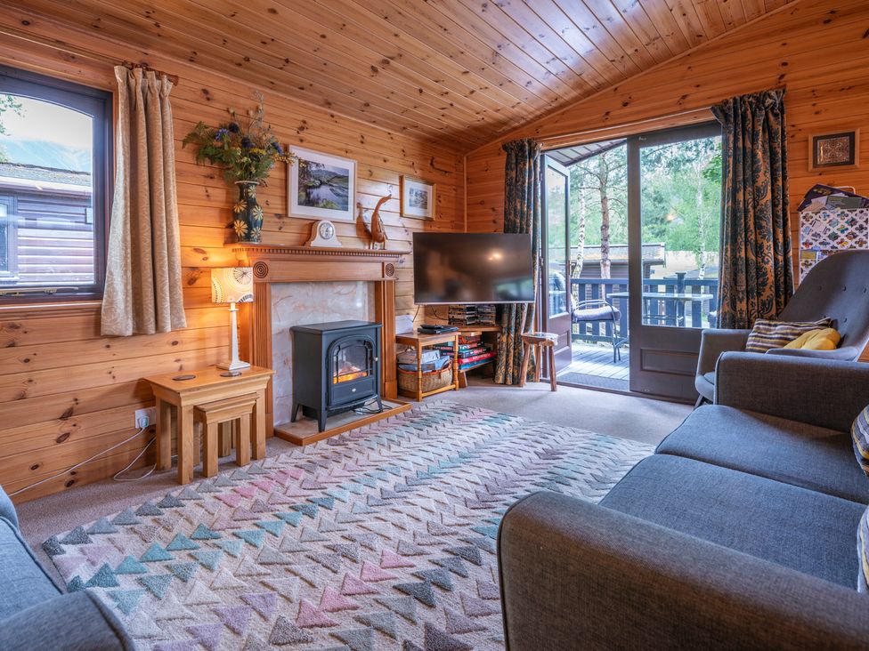 A living room with a fireplace and a sofa at Watendlath in Keswick