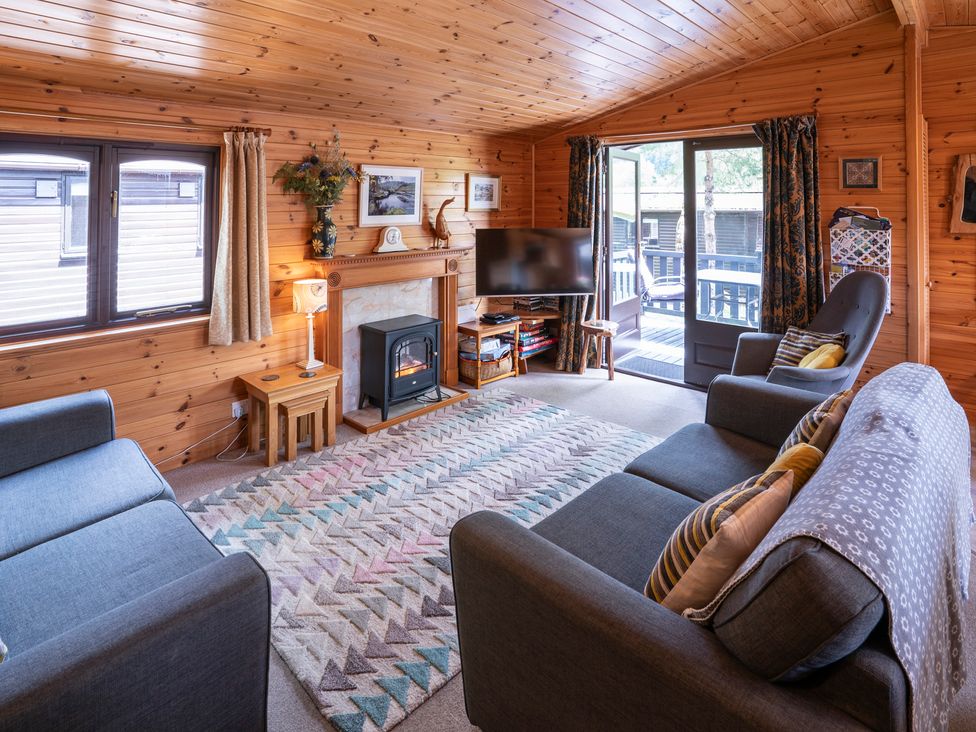 A living room with a fireplace and sofa at Watendlath in Keswick