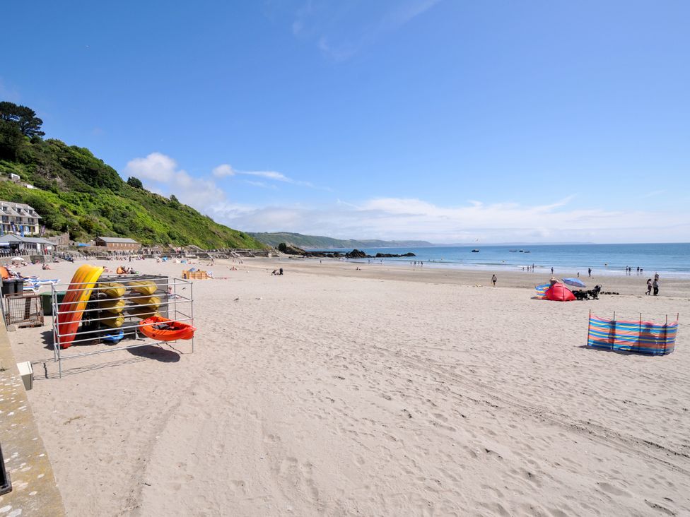 A beach with people and kayaks at Sea Pinks in Looe