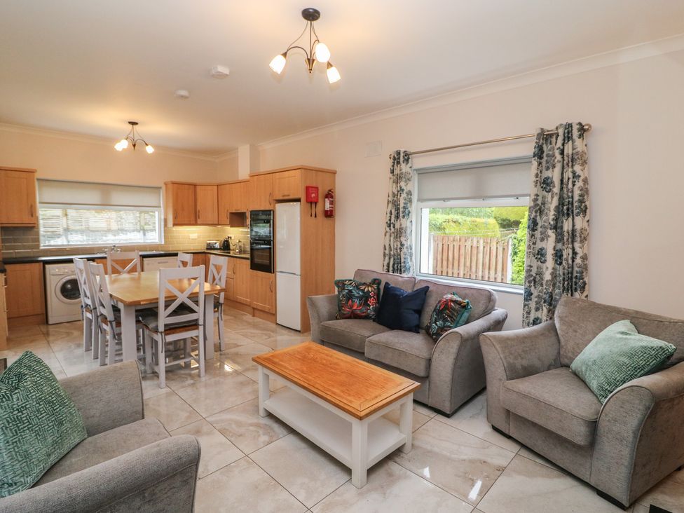 A living room with a kitchen area and dining table at No 1 Lodge Wood, Kenmare, County Kerry