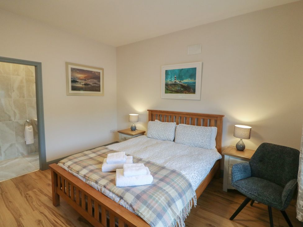 A bedroom with a bed and nightstand at No 1 Lodge Wood, Kenmare, County Kerry