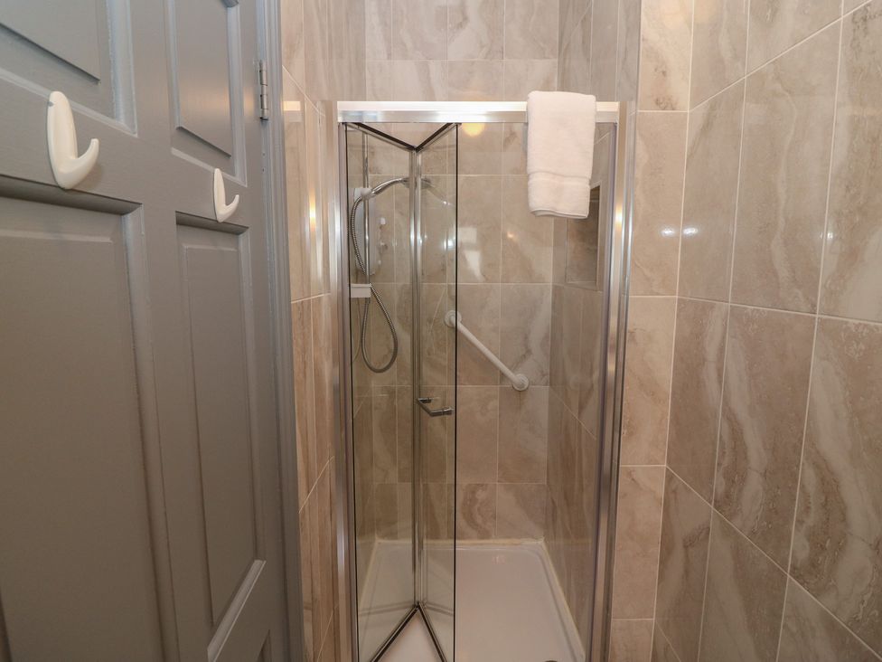 A shower enclosure with a towel inside the bathroom at No 1 Lodge Wood, Kenmare, County Kerry