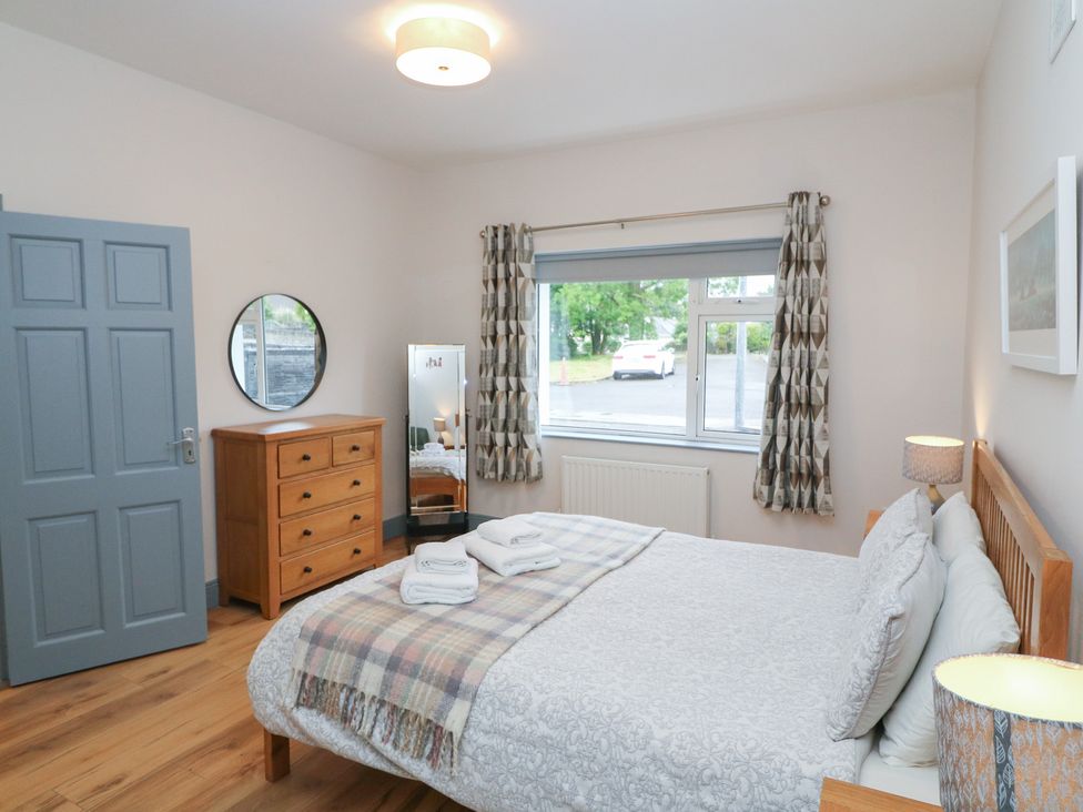 A bedroom with a bed and a dresser at No 1 Lodge Wood in Kenmare, County Kerry