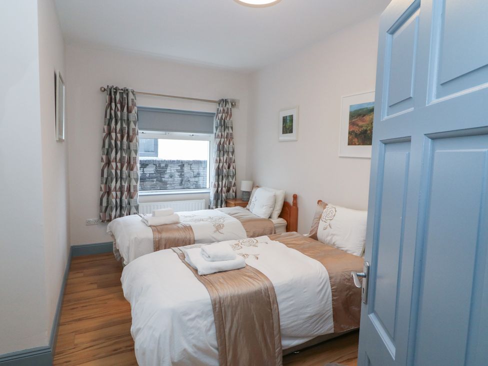 A bedroom with two beds and art on the walls at No 1 Lodge Wood, Kenmare, County Kerry