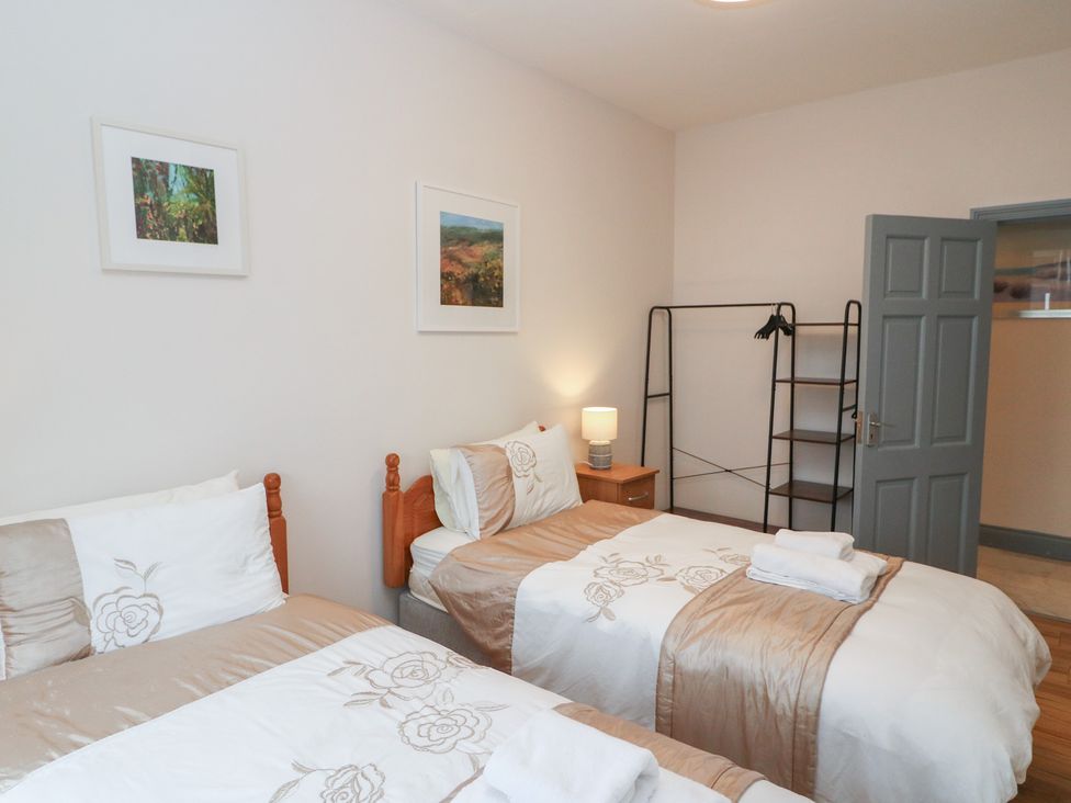 A bedroom with two beds and a shelf at No 1 Lodge Wood in Kenmare, County Kerry