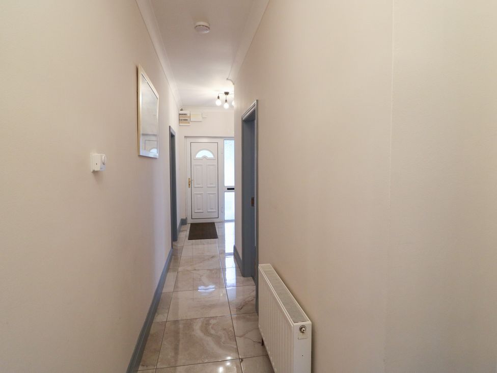 A hallway with a front door and mirror at No 1 Lodge Wood, Kenmare, County Kerry