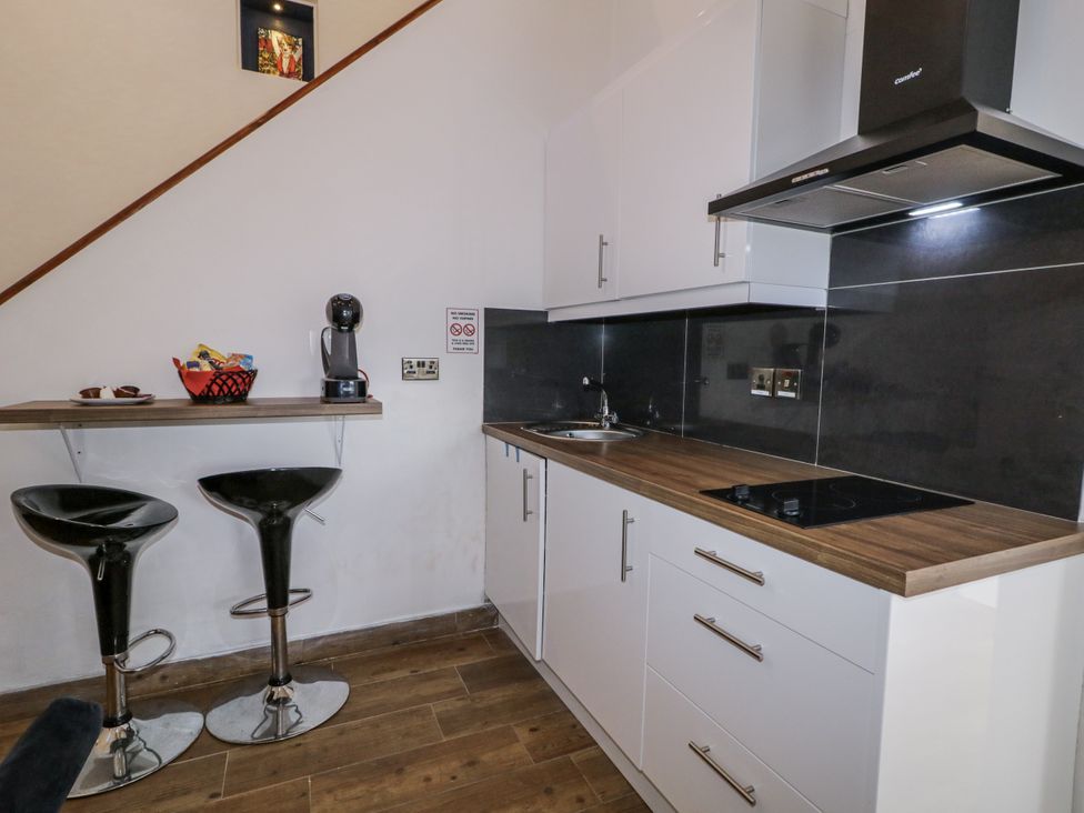 A kitchenette with bar stools and coffee machine at Derrywilligan 1,2,3 Newry