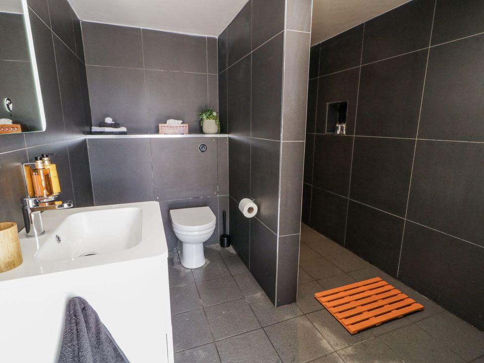 A bathroom with a sink, toilet and shelves at Derrywilligan 1,2,3 in Newry