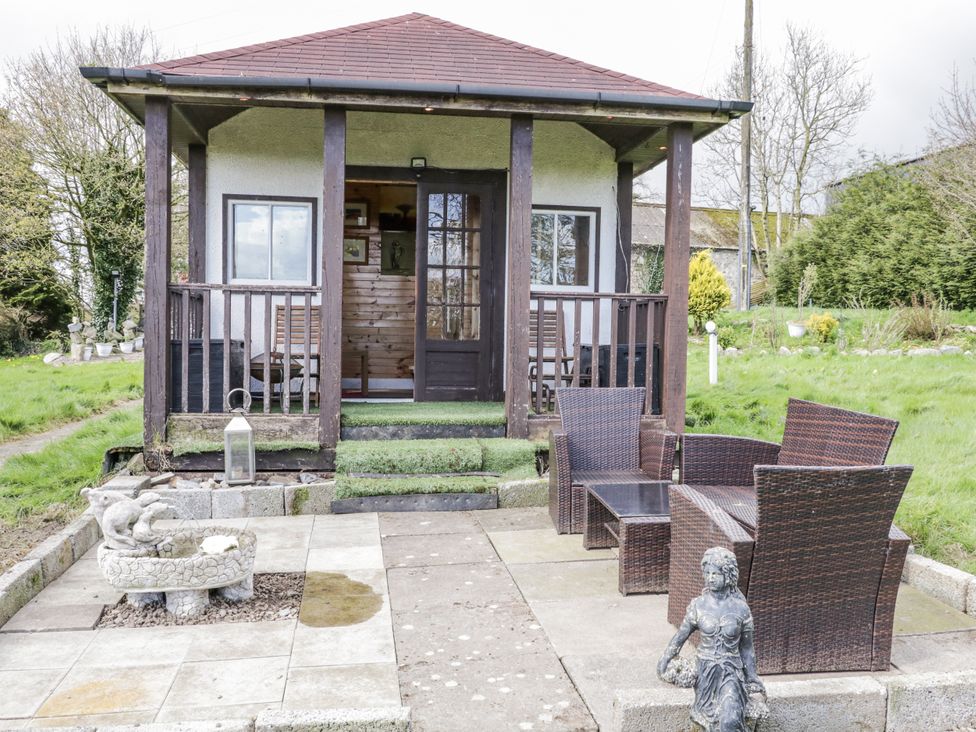 A cottage with a porch and patio furniture at Derrywilligan 1,2,3 in Newry