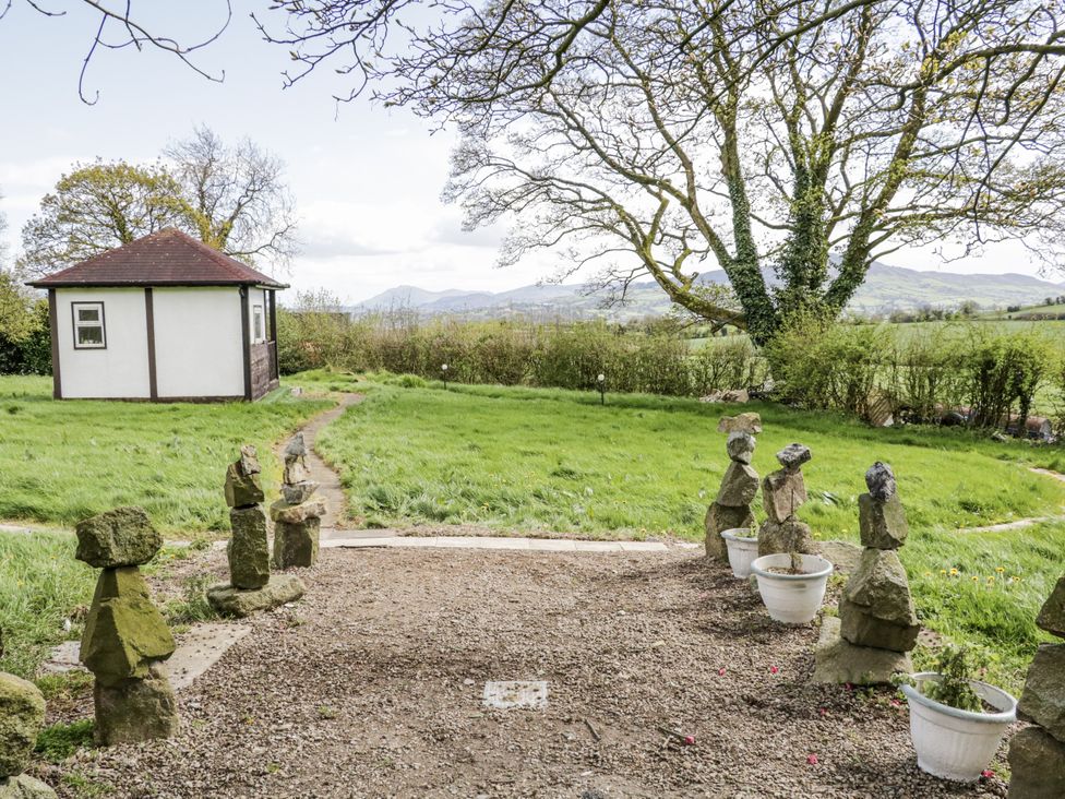A garden with a shed and stone sculptures at Derrywilligan 1,2,3 in Newry