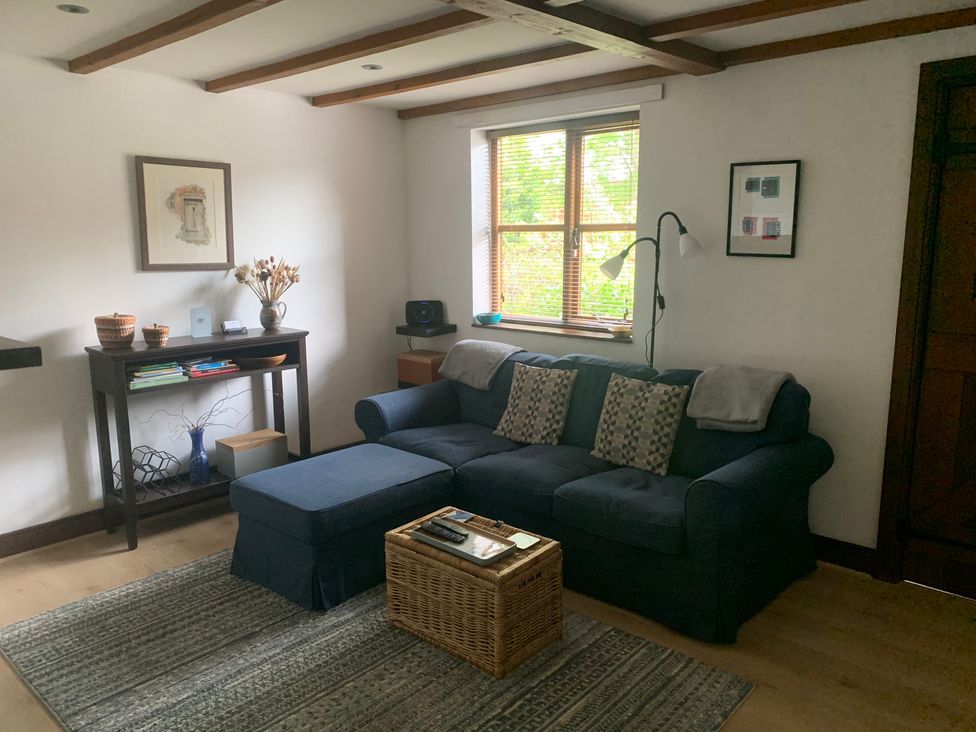 A living room with a sofa, coffee table, and lamp at Old Town Cottage in Stratford-Upon-Avon