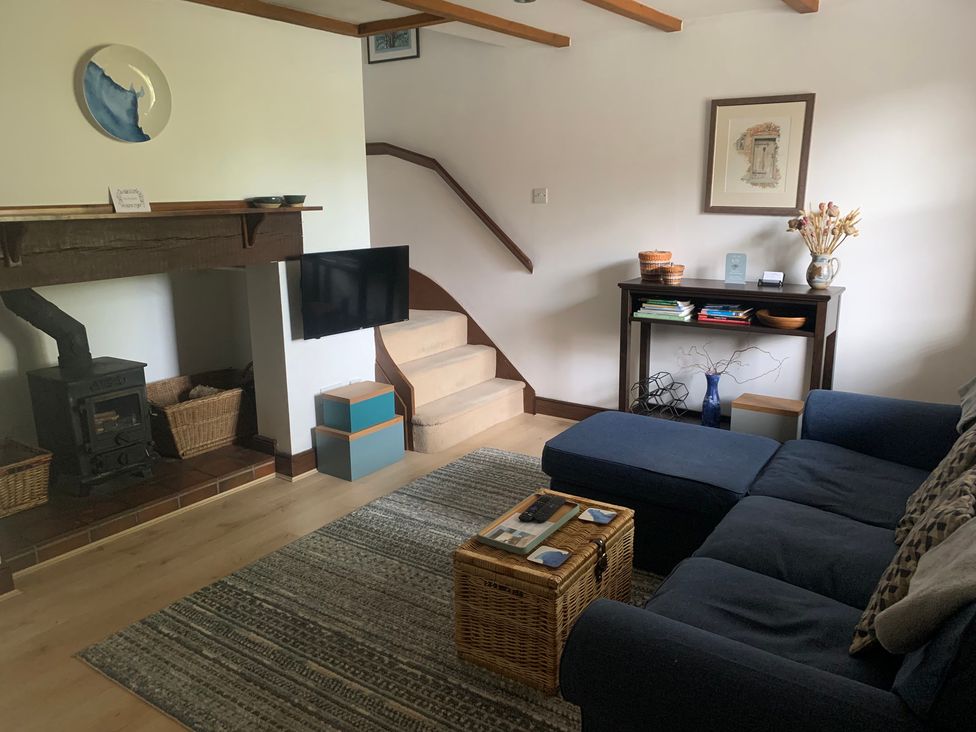 A living room with a sofa and television at Old Town Cottage in Stratford-Upon-Avon
