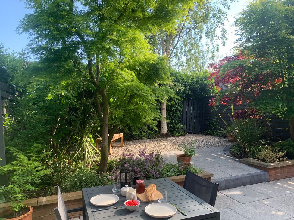 A garden with a table set for breakfast at Old Town Cottage in Stratford-Upon-Avon