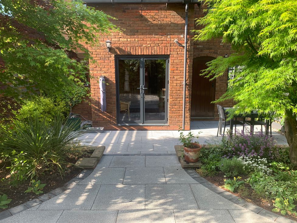 A garden with a pathway and seating area at Old Town Cottage Stratford-Upon-Avon