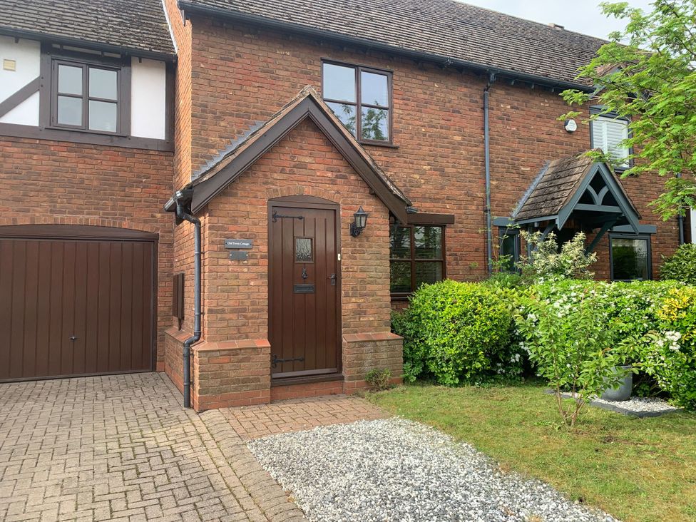 A house with a wooden front door and garden at Old Town Cottage Stratford-Upon-Avon