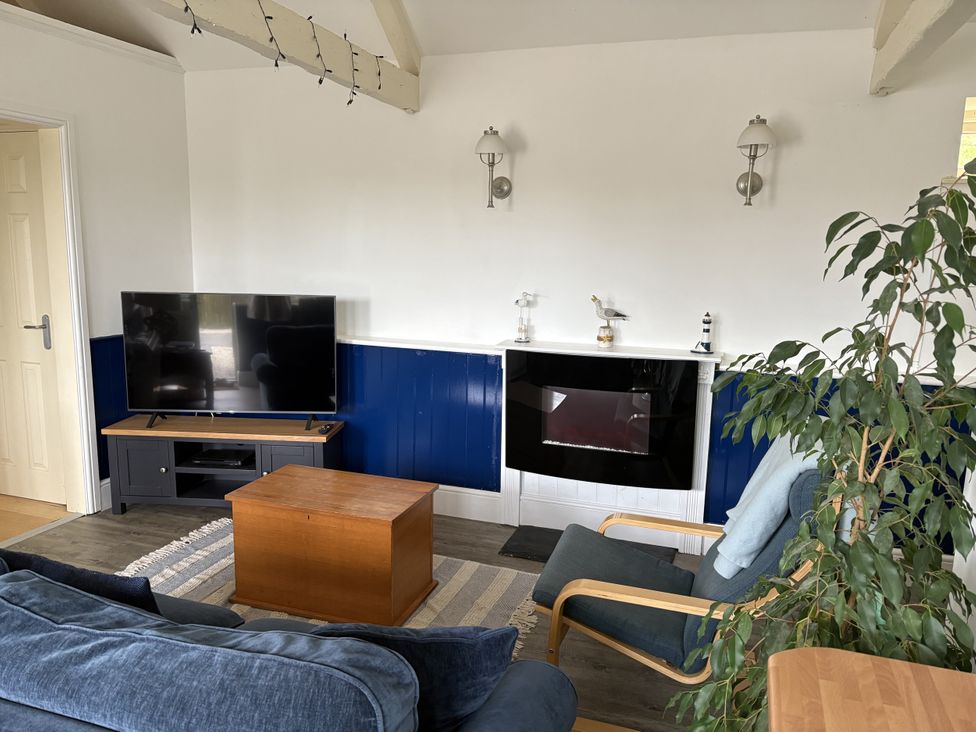 A living room with a television and a coffee table at Lighthouse Cottage in St Erme near Truro