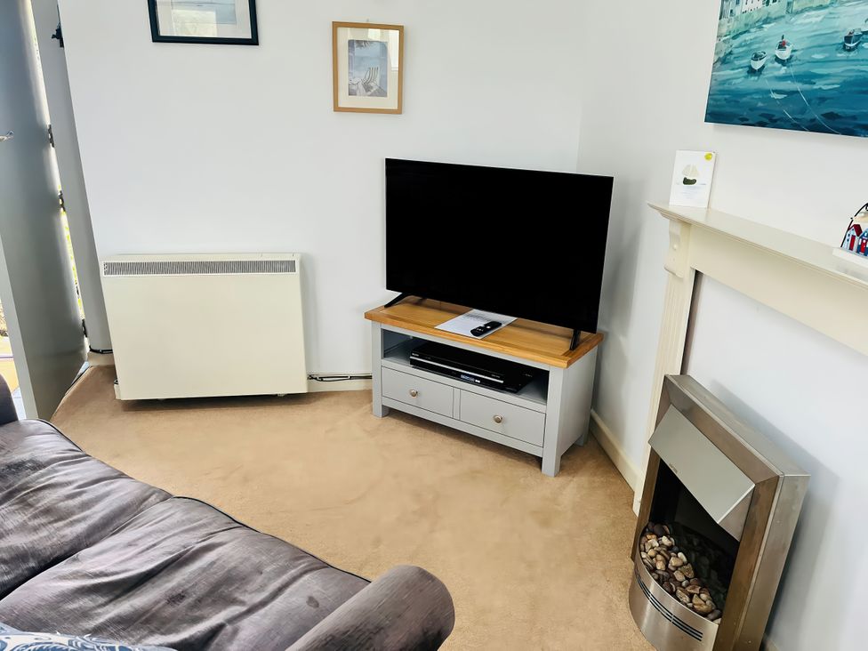 A living room with a television and a sofa at Lighthouse Cottage in St Erme near Truro