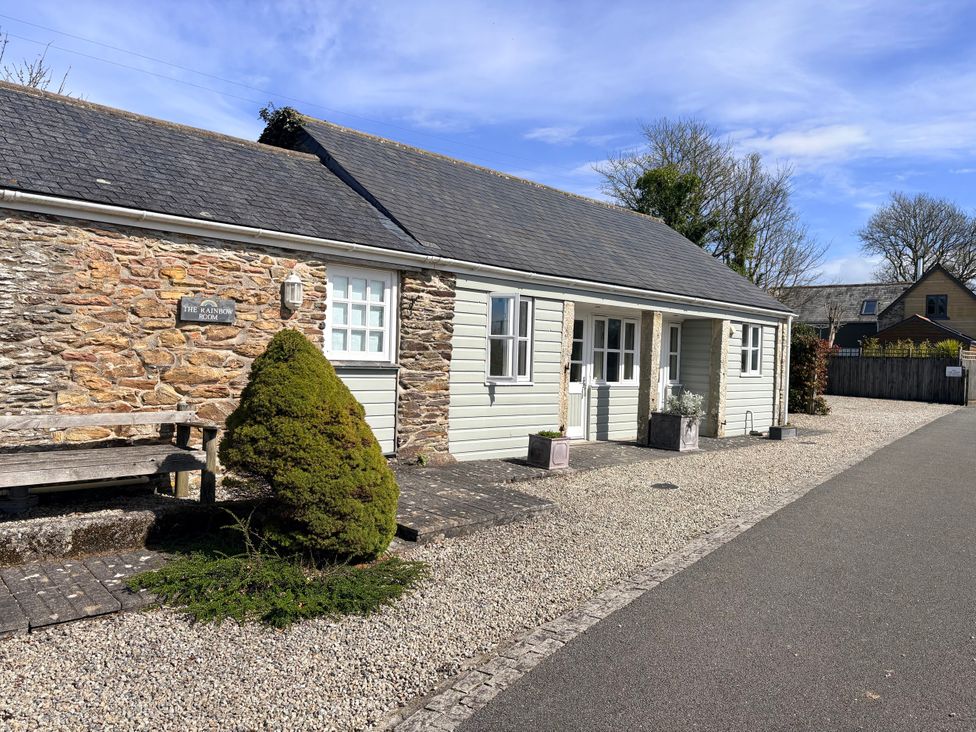 A house with a stone wall and bench at Lighthouse Cottage St Erme near Truro