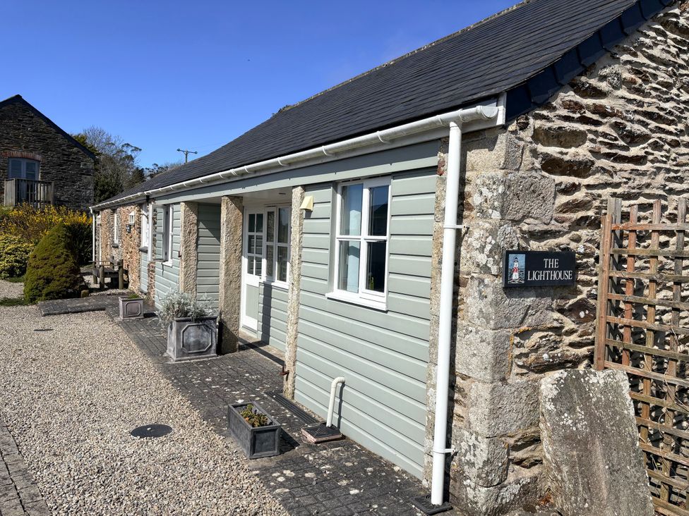 An outdoor view of a cottage with a sign at Lighthouse Cottage St Erme near Truro