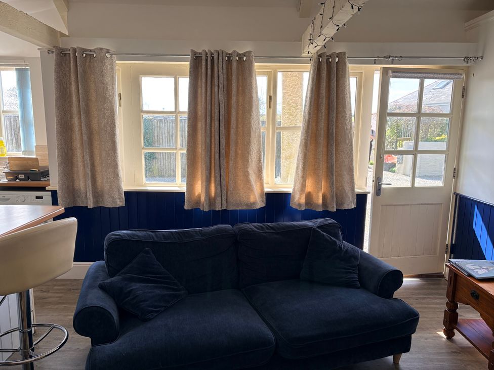 A living room with a sofa and windows at Lighthouse Cottage St Erme near Truro