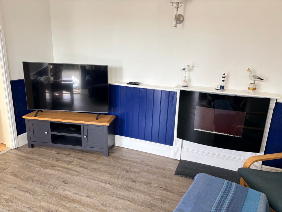 A living room with a television and fireplace at Lighthouse Cottage St Erme near Truro