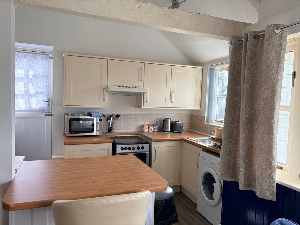 A kitchen with appliances and a countertop at Lighthouse Cottage St Erme near Truro