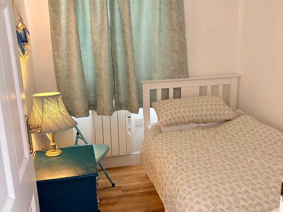 A bedroom with a bed and lamp at Lighthouse Cottage in St Erme near Truro