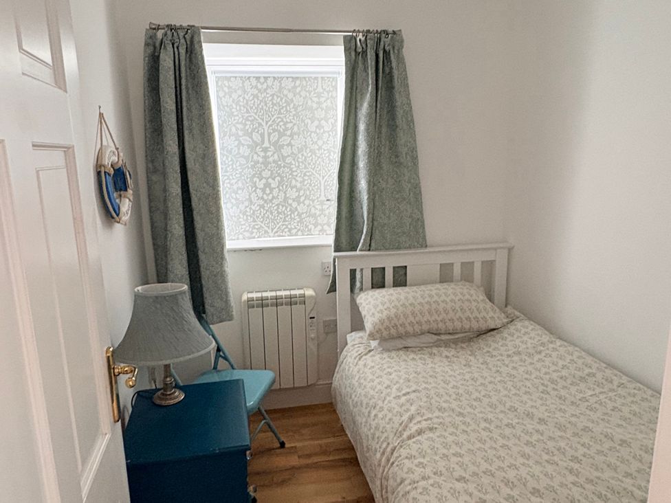 A bedroom with a bed and lamp at Lighthouse Cottage in St Erme near Truro