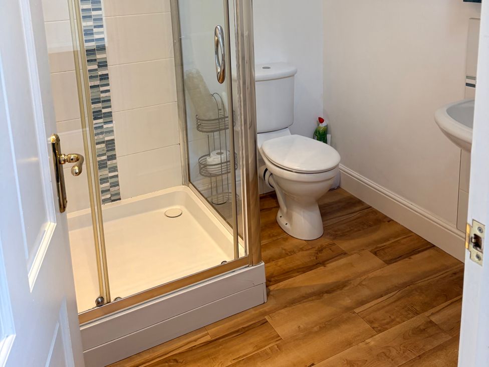 A bathroom with a shower, toilet and sink at Lighthouse Cottage in St Erme near Truro