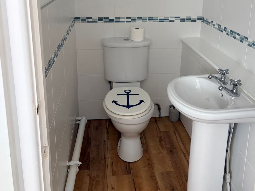 A toilet and sink in a bathroom at Lighthouse Cottage St Erme near Truro