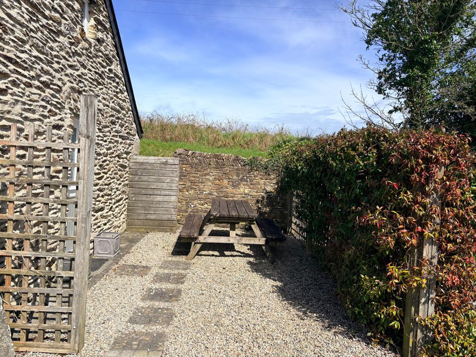 An outdoor space with a bench table at Lighthouse Cottage in St Erme near Truro