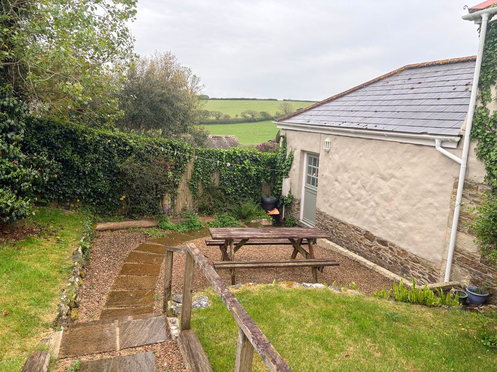 A garden with a picnic table and step pathway at Sunlight Cottage St Erme near Truro