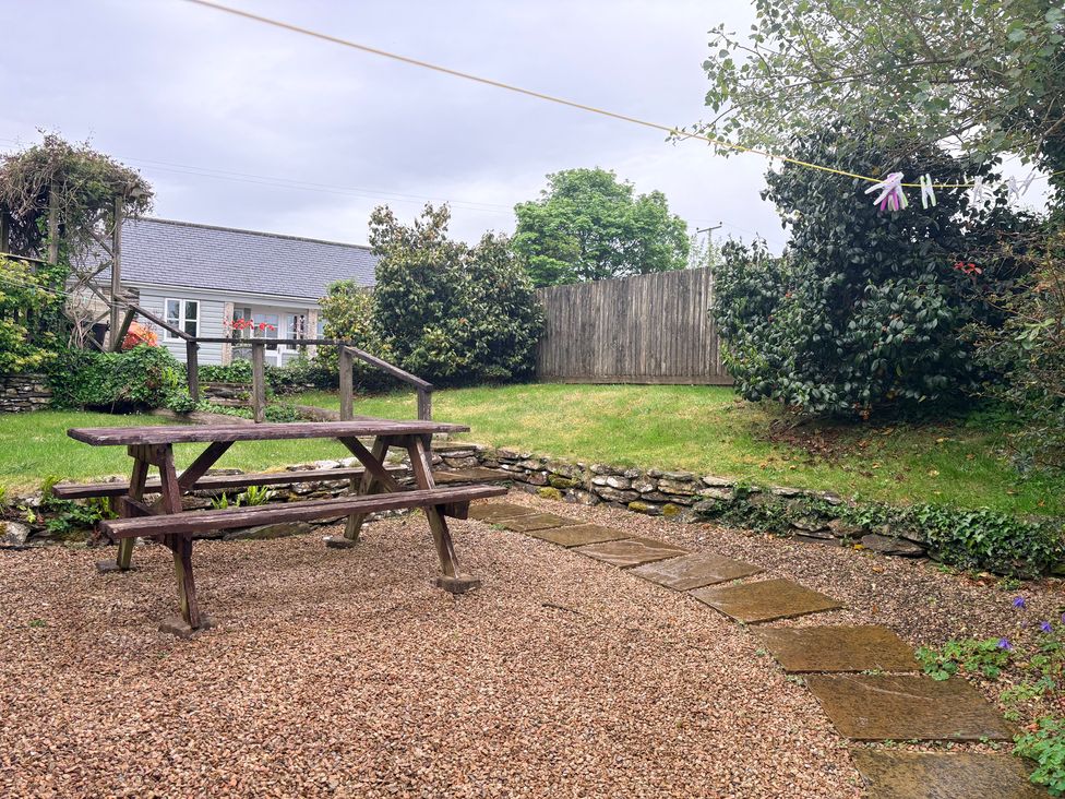 A garden with a picnic table and gravel path at Sunlight Cottage in St Erme near Truro