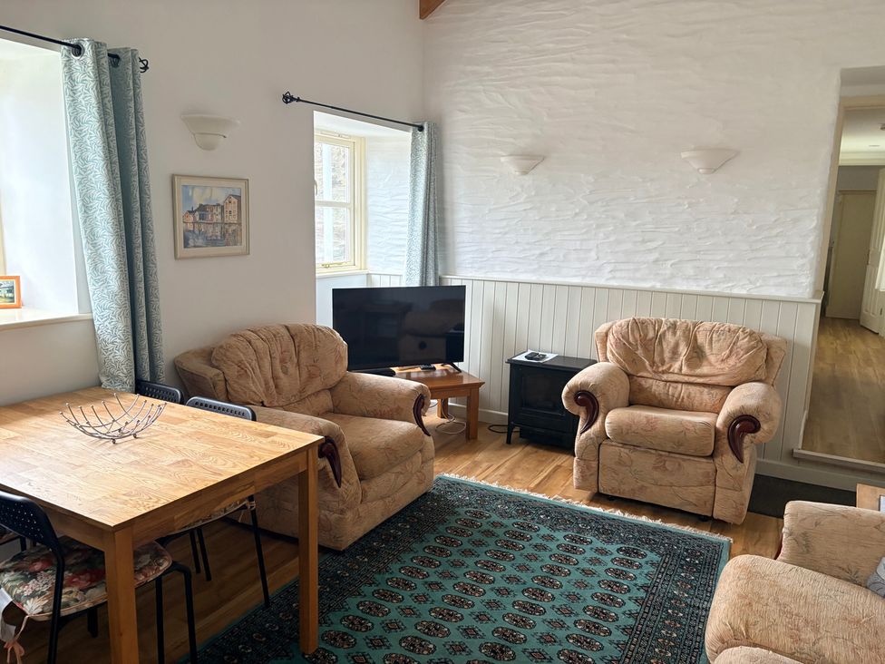 A living room with seating and a television at Sunlight Cottage in St Erme near Truro