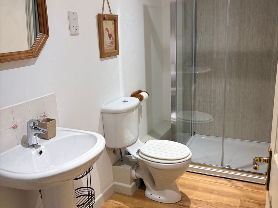 A bathroom with a sink, toilet, and shower at Sunlight Cottage St Erme near Truro